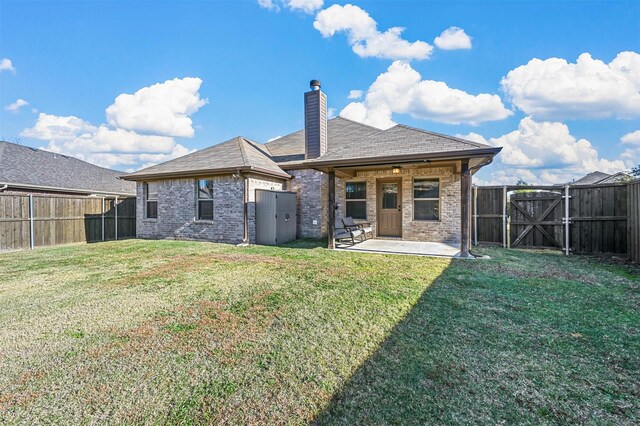 rear view of house with a patio area and a lawn