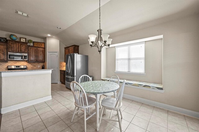 dining area featuring light tile patterned flooring, lofted ceiling, and an inviting chandelier