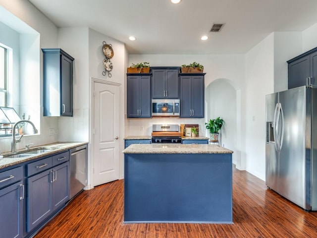 kitchen with sink, backsplash, a center island, and appliances with stainless steel finishes