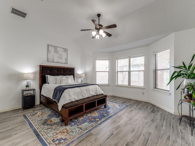 bedroom with multiple windows, light hardwood / wood-style floors, and lofted ceiling