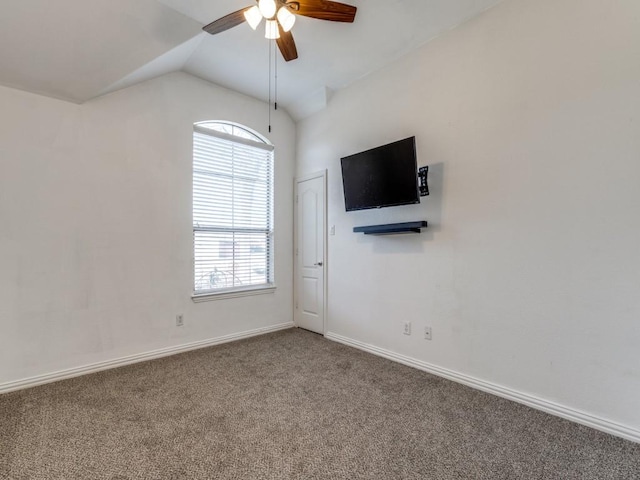 carpeted spare room featuring vaulted ceiling and ceiling fan