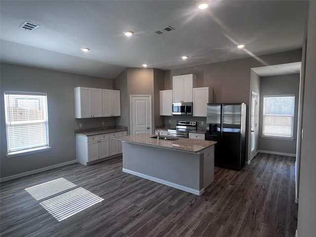 kitchen with white cabinets, an island with sink, a healthy amount of sunlight, and appliances with stainless steel finishes