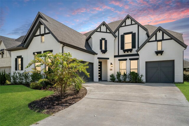 tudor house featuring a front lawn and a garage