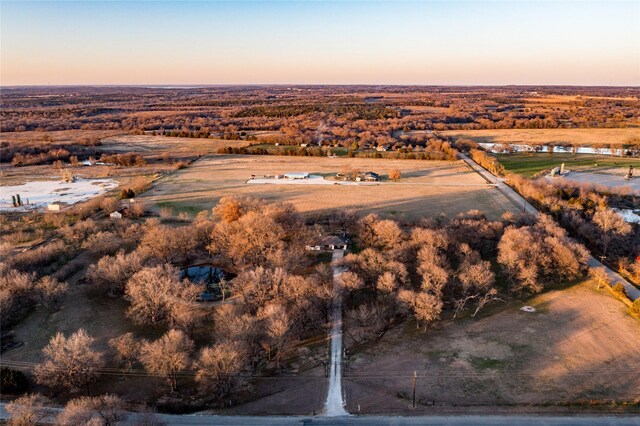 aerial view at dusk with a water view and a rural view