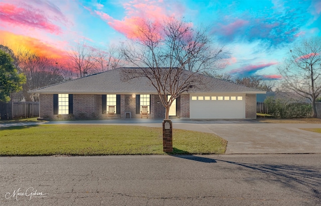 ranch-style house with a garage and a lawn