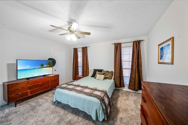 carpeted bedroom featuring a textured ceiling and ceiling fan