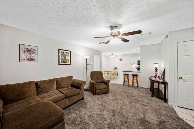 carpeted living room with a textured ceiling and ceiling fan