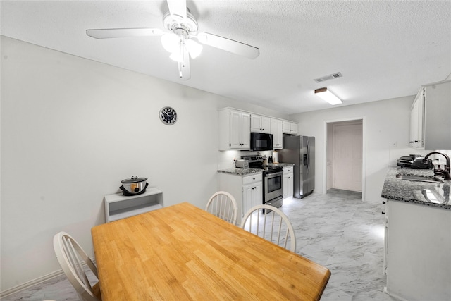 dining room with sink, ceiling fan, and a textured ceiling