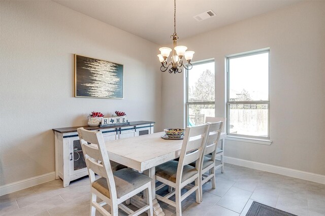 dining area featuring light tile patterned floors and an inviting chandelier