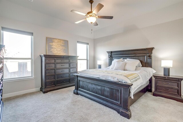 bedroom featuring ceiling fan, light colored carpet, and vaulted ceiling