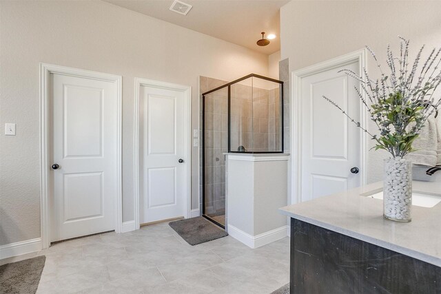 bathroom with a shower with door and sink