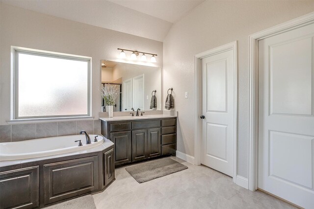 bathroom with tile patterned flooring, vanity, a bathtub, and lofted ceiling