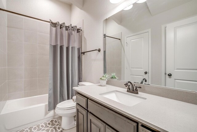 full bathroom featuring shower / bath combo, vanity, and toilet