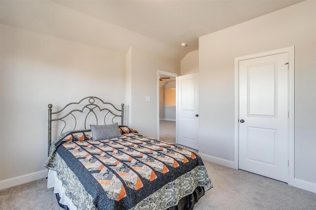 bedroom with light carpet and vaulted ceiling