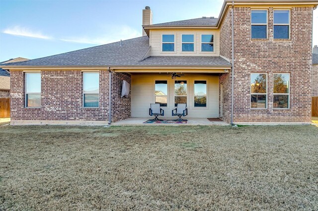 rear view of property with a lawn and a patio