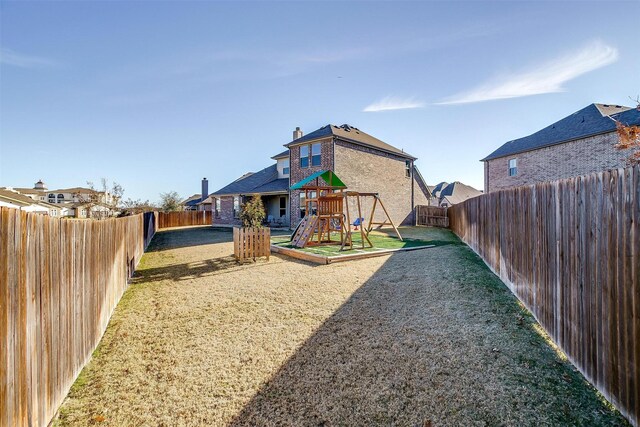 rear view of house with a playground and a lawn