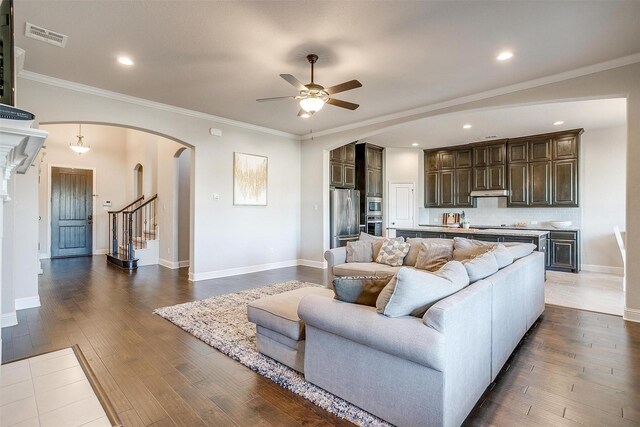 living room featuring hardwood / wood-style floors, ceiling fan, and ornamental molding