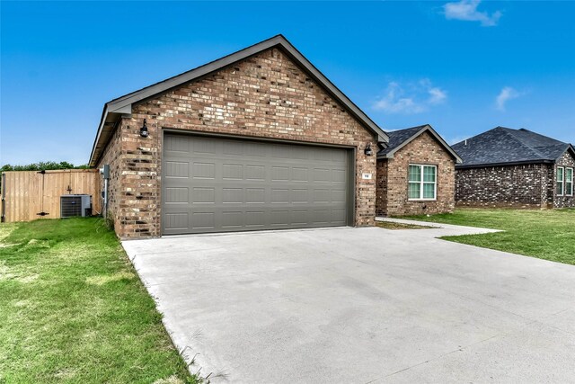 view of front of house featuring a garage, central air condition unit, and a front yard