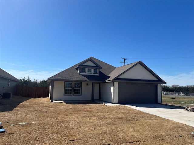 view of front of home with fence, cooling unit, concrete driveway, an attached garage, and a shingled roof