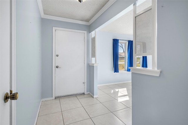 foyer entrance featuring light tile patterned flooring, a textured ceiling, and ornamental molding