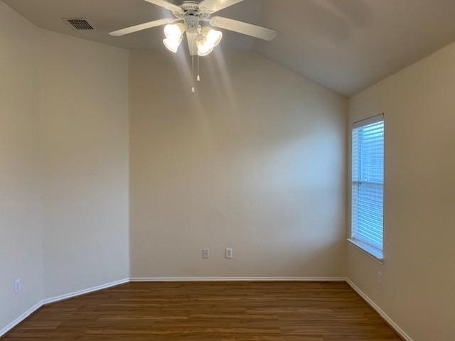 empty room with ceiling fan, lofted ceiling, and dark hardwood / wood-style flooring