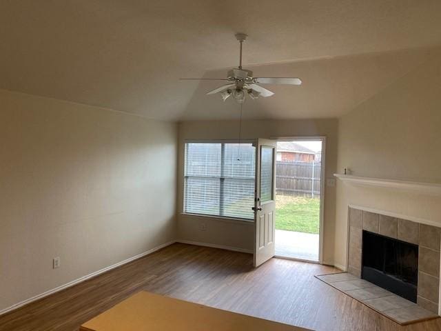 entryway with vaulted ceiling, a fireplace, light hardwood / wood-style floors, and a wealth of natural light