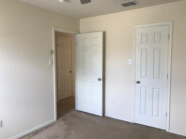 unfurnished bedroom with dark colored carpet