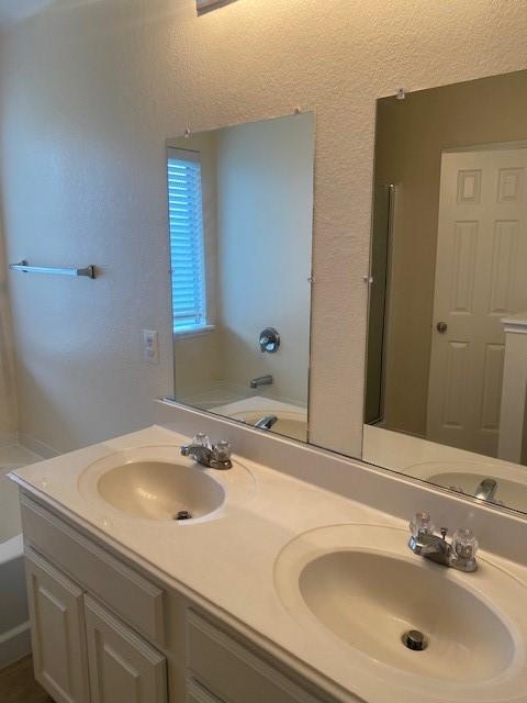 bathroom featuring vanity and a bath