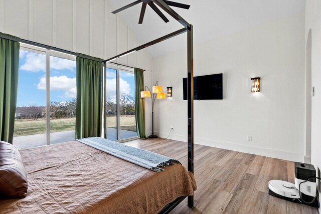 bedroom with access to exterior, multiple windows, ceiling fan, and light wood-type flooring