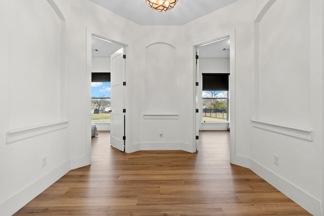 hall with hardwood / wood-style floors and a notable chandelier