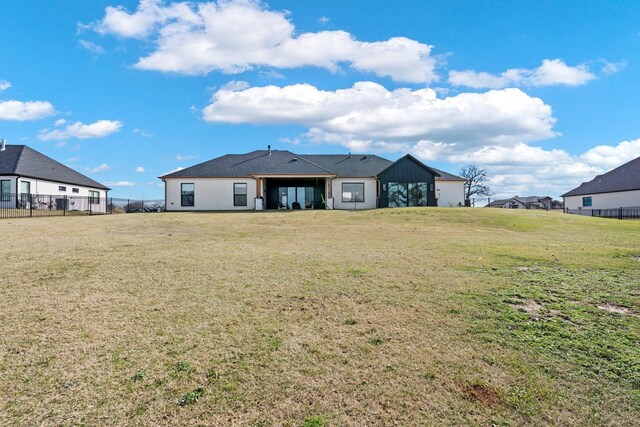 rear view of property featuring a lawn