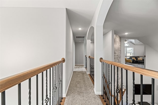 hallway with carpet and vaulted ceiling