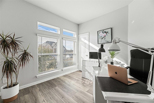 office space with baseboards and light wood-style floors