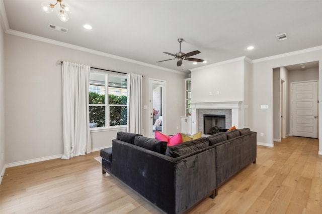 living room featuring ceiling fan, ornamental molding, and light hardwood / wood-style flooring