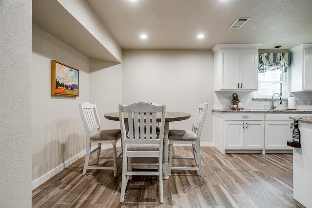 dining space with light hardwood / wood-style flooring and sink