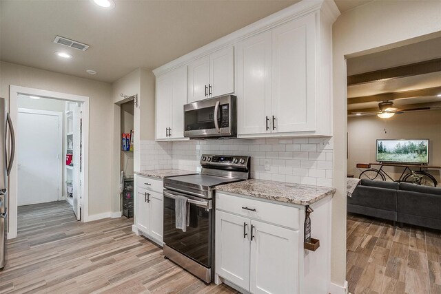 kitchen featuring light stone countertops, white cabinetry, and stainless steel appliances