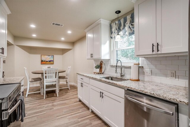 kitchen featuring white cabinetry, sink, light stone countertops, hanging light fixtures, and stainless steel appliances