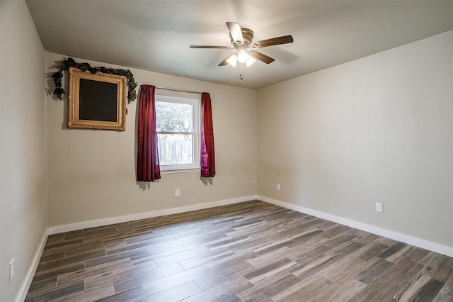 spare room with ceiling fan and wood-type flooring