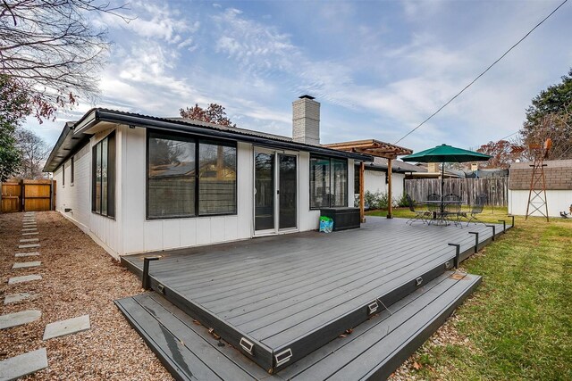 wooden deck featuring a storage shed and a lawn