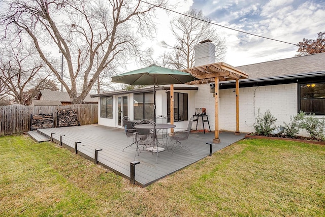 back of house featuring a pergola, a wooden deck, a sunroom, and a lawn