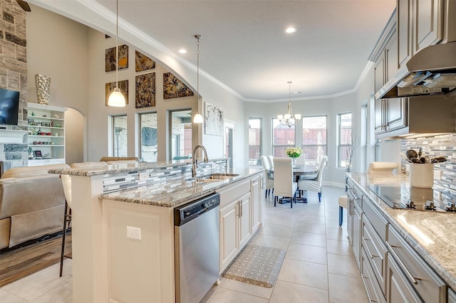 kitchen with sink, a kitchen bar, hanging light fixtures, a kitchen island with sink, and stainless steel dishwasher