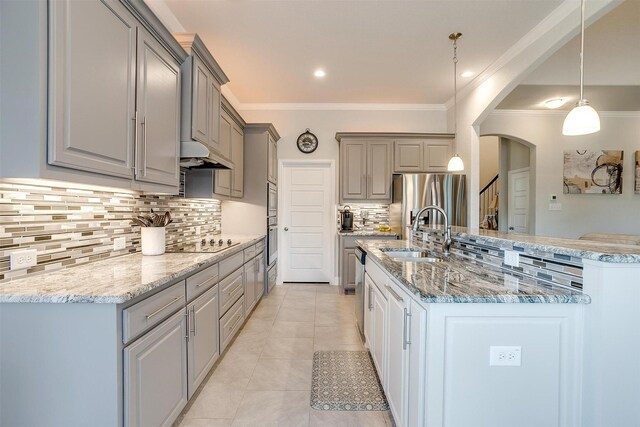 kitchen featuring light tile patterned flooring, appliances with stainless steel finishes, sink, hanging light fixtures, and ornamental molding