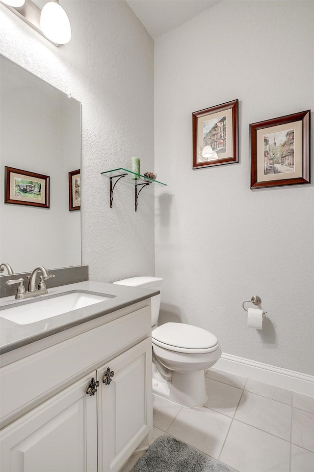 bathroom featuring vanity, tile patterned floors, and toilet