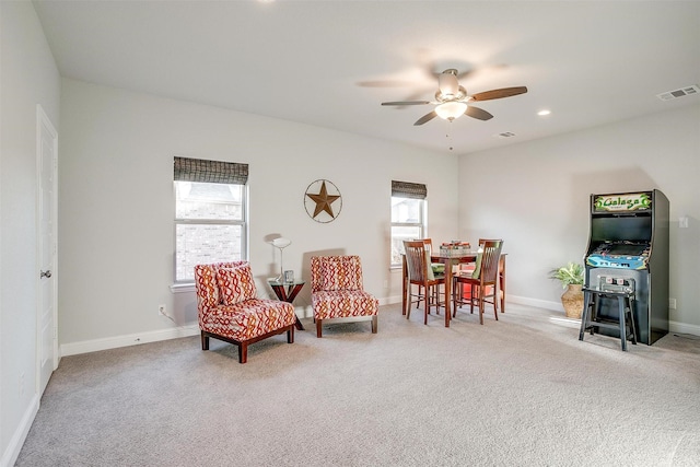 sitting room with ceiling fan and carpet