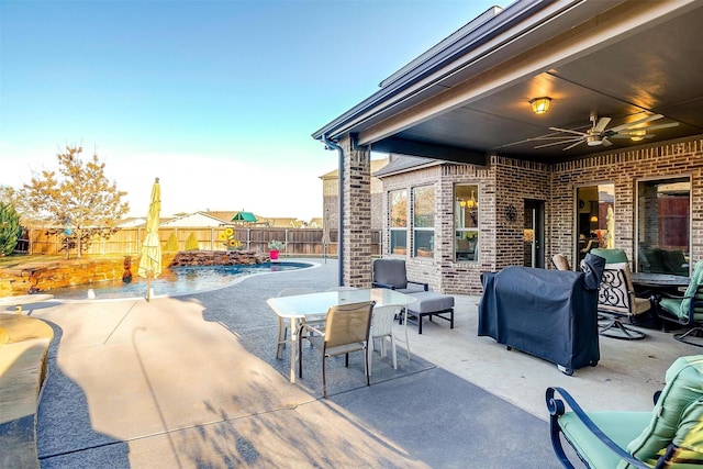 view of patio with ceiling fan, a grill, and a fenced in pool