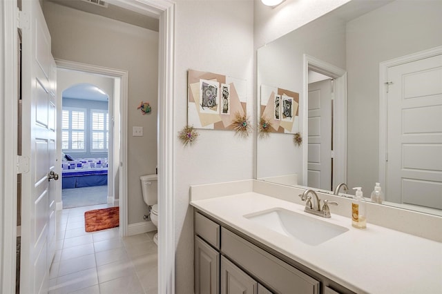 bathroom with tile patterned flooring, vanity, and toilet