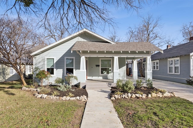 bungalow with a porch and a front lawn