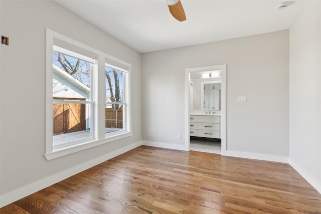 unfurnished bedroom featuring connected bathroom, ceiling fan, and light wood-type flooring