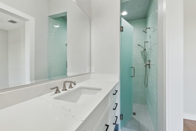 bathroom with vanity and a shower with shower door