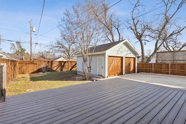 wooden terrace featuring a lawn, a garage, and an outdoor structure